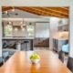 A cozy kitchen and dining room with a rustic wooden ceiling, creating a warm and inviting atmosphere.