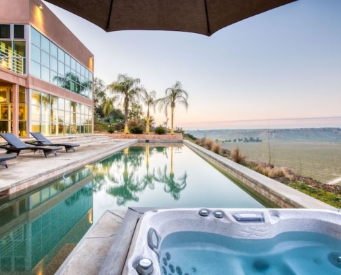 A serene scene of a hot tub and pool beside the mountains, offering a relaxing and picturesque view.