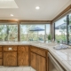 A kitchen with a sink and a large window providing ample natural light.