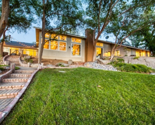 A spacious home with a vast lawn and inviting steps leading up to it, creating an elegant entrance.