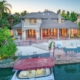 A spacious home with a boat dock and a pier by the water.