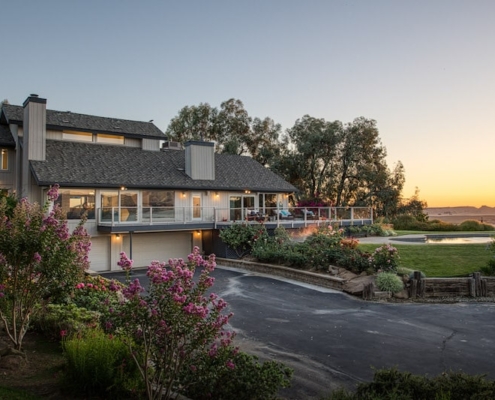 A spacious home with a wide driveway leading up to the entrance.
