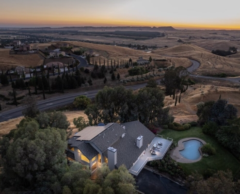 Aerial view of a house and pool surrounded by a vast field. Aerial view of a house and pool surrounded by a vast field.