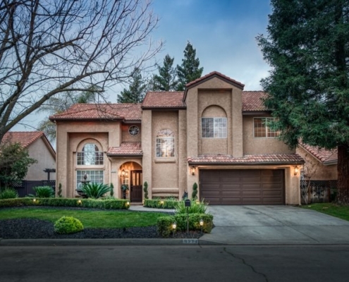 Photo of exterior front view of two story home with well groomed landscaping